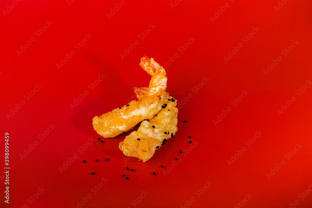 King prawns in batter, sprinkled with sesame seeds. Festive dinner. Healthy eating. On a red background. King prawns in batter, sprinkled with sesame seeds. Festive dinner. Healthy eating. On a red background.