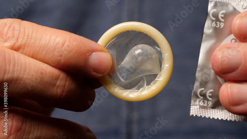 Male Hands Taking a Condom, Macro