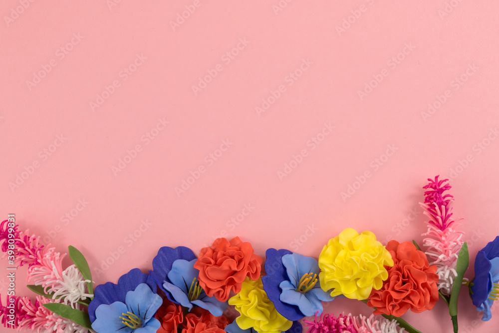 Pastel floral composition, pink background and frame of decorative flowers, copy space, place for text, spring flat lay