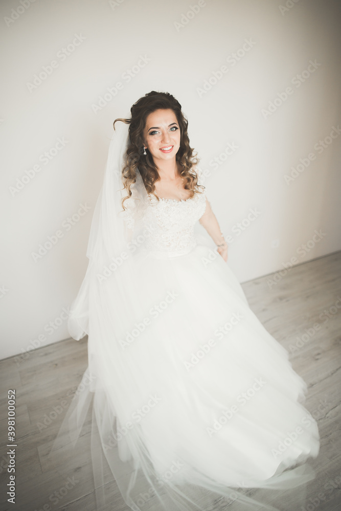 Luxury bride in white dress posing while preparing for the wedding ceremony