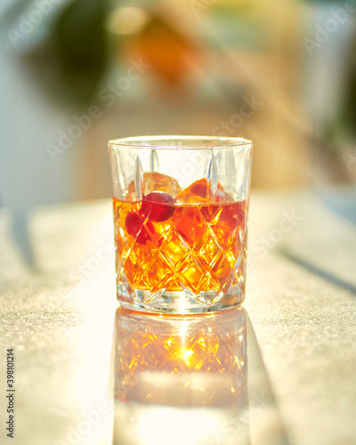 Cocktail Glass with Whiskey or Brown Liquor on Bright Table