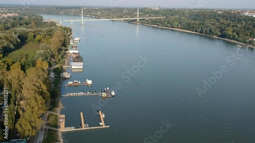 Aerial drone view of a bridge over the river Danube. Docks with boats. Vertical climb.  photo