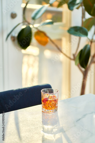 Cocktail Glass with Whiskey or Brown Liquor on Bright Table
