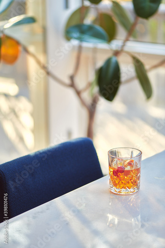 Cocktail Glass with Whiskey or Brown Liquor on Bright Table