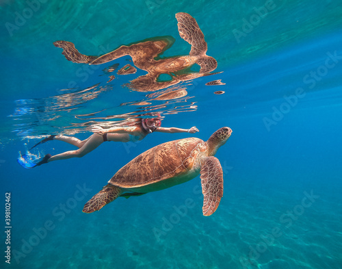 Sea. A girl in an underwater mask swims in the sea with a large turtle. Egypt. Red sea.