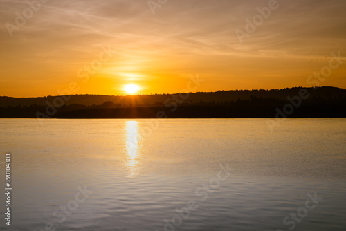 Dreamy scene of sunrise and dawn with a colorful sky in the background and water in the foreground. Image depicting tranquility and calm with copyspace 