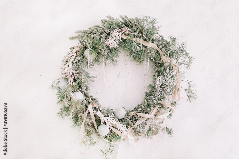 Christmas wreath with fir branches and decorations hanging on white wall. Merry Christmas. Festive holiday decoration. Christmas wreath with fir branches and decorations hanging on white wall. Merry Christmas. Festive holiday decoration.