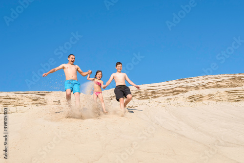 Happy family on the beach are running on the sand. Family on beach vacation, healthy lifestyle, vacation, vacation