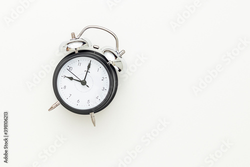 Classic black table clock isolated on a white background, view from above. Selective focus. Top view. Business concept.