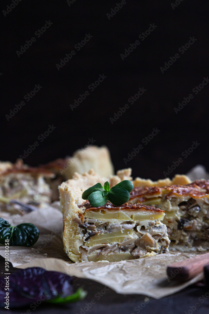 Homemade chicken, mushroom and potato open pie or quiche, dark rustic concrete background. French cuisine. Homemade chicken, mushroom and potato open pie or quiche, dark rustic concrete background. French cuisine.