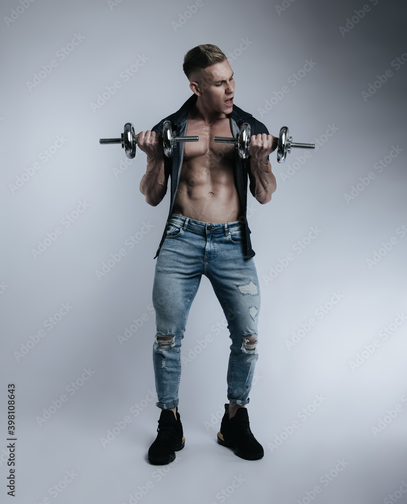 Full length portrait of training young man with dumbbells on light background Full length portrait of training young man with dumbbells on light background
