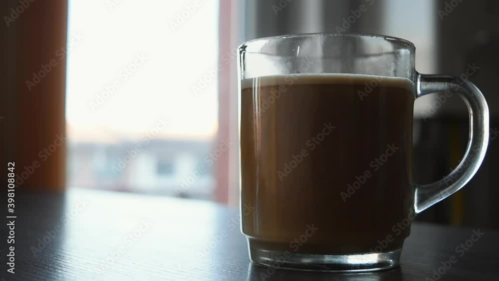 Milk pouring into creamy delicious coffee in slow motion. Delicious beverage in the morning. Great way to start the day. Milk pouring into creamy delicious coffee in slow motion. Delicious beverage in the morning. Great way to start the day.