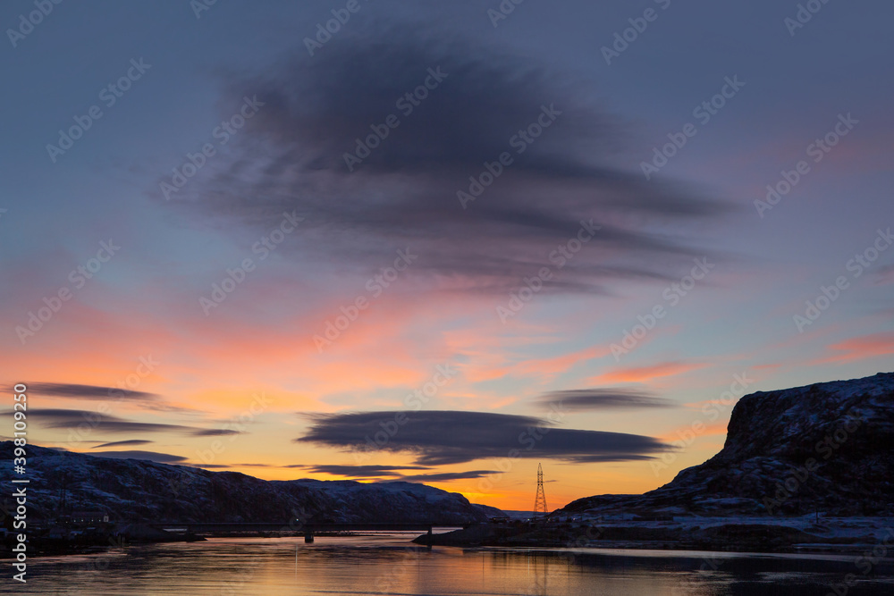 Beautiful bright sunrise over the river. Formation of a lenticular cloud. Landscape photography. Beautiful bright sunrise over the river. Formation of a lenticular cloud. Landscape photography.
