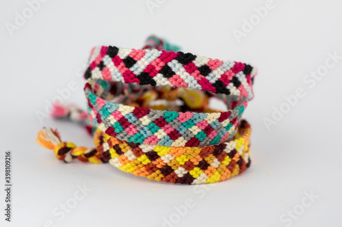 Group of handmade homemade colorful natural woven bracelets of friendship isolated on white background