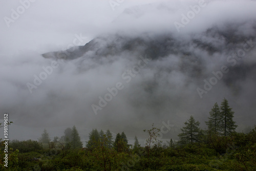 Altai mountains shrouded in white clouds, it looks quite gloomy © Павел Чигирь