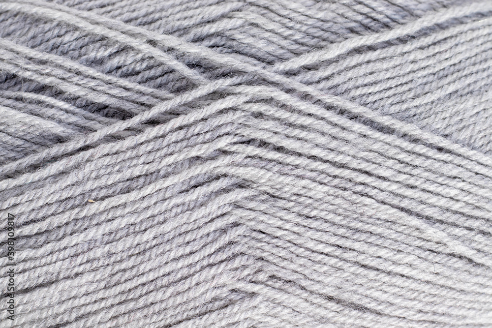 knitting in gray on a white background with space for text.gray balls of thread