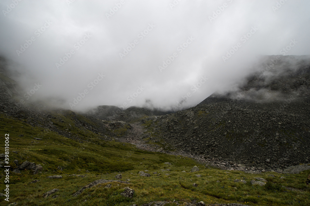 Altai mountains shrouded in white clouds, it looks quite gloomy