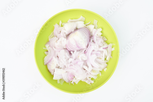 Sliced fresh white onions in a green bowl isolated on a white background. Top view.
