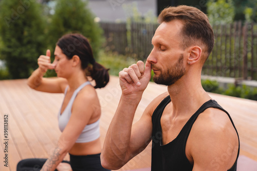 Close up photo of two caucasian yogi breathing deeply with one nostril during yoga class
