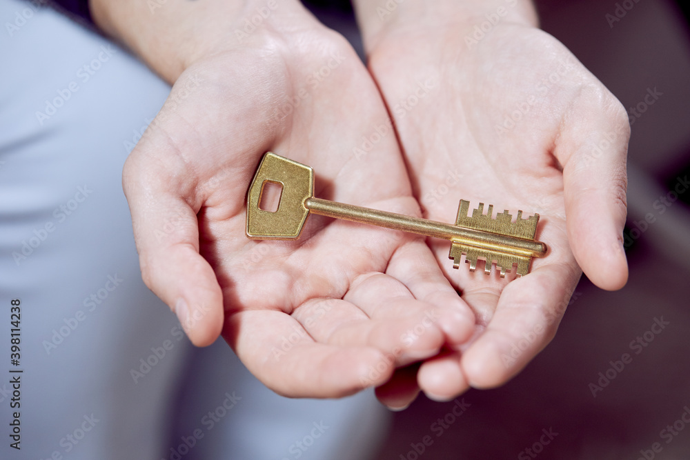 Fototapeta premium Close up of human hand holding golden key