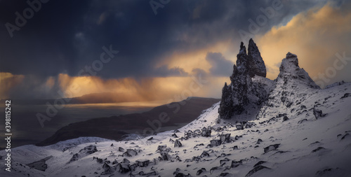 Old Man Storr, Isle Skye, Scotland. Winter, very snowy mountain in a very powerful sunrise with some storm clouds in the middle of the sunrise. Very interesting hot and cold contrasts.Commercial shoot