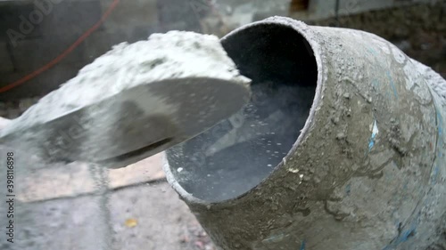 Construction worker shoveling cement into a cement mixer