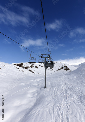 Chair-lift with skiers at winter mountains