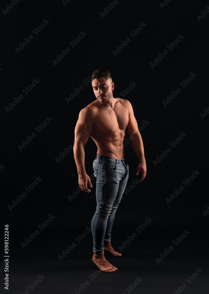 strong caucasian man without shirt and jeans posing against black background handsome model with barefoot style strong caucasian man without shirt and jeans posing against black background handsome model with barefoot style