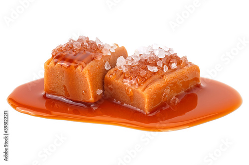 Salted caramel candies with caramel sauce isolated on a white background. Caramel candies with sea salt.