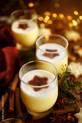 Christmas eggnog decorated with ground cinnamon star-shaped close-up. Delicious homemade festive drink
