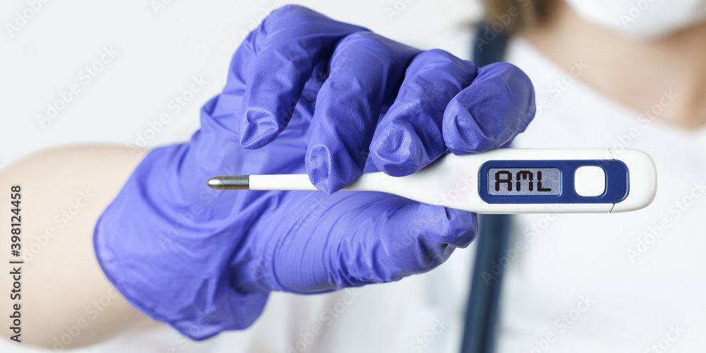 The doctor holds a thermometer in his hands, on the electronic screen of which it is written - AML The doctor holds a thermometer in his hands, on the electronic screen of which it is written - AML
