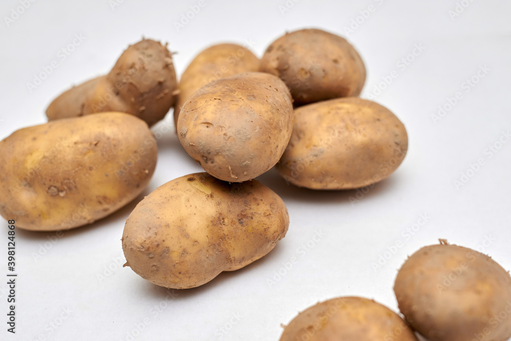 fresh unpeeled potatoes on a white background fresh unpeeled potatoes on a white background