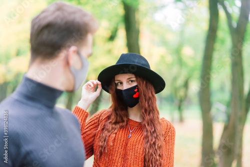 Young couple wearing masks together in forest © Ivan Zelenin