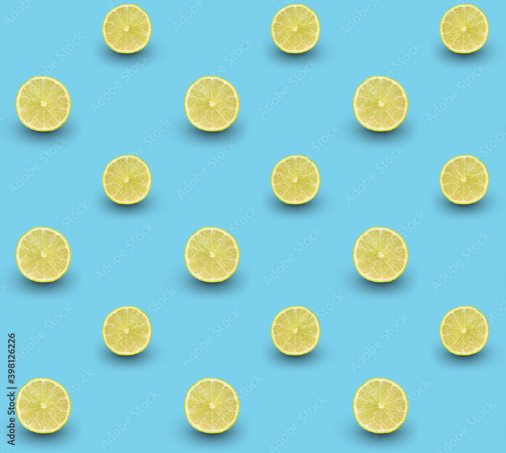 Repeated seamless pattern of many sliced ripe limes on light blue background.