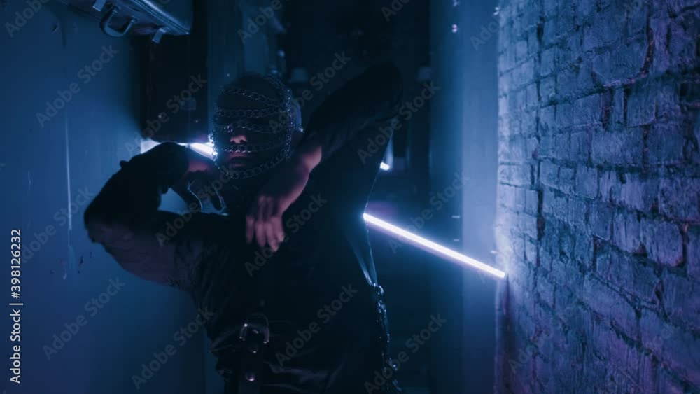 Sexy dancer man in the chain mask on the dark night club background. Filmed in fluorescent clothing under UV black light. Club party glamor style. Creative art Sexy dancer man in the chain mask on the dark night club background. Filmed in fluorescent clothing under UV black light. Club party glamor style. Creative art