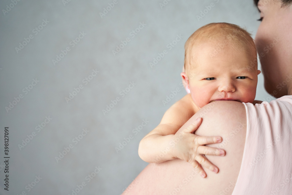 Newborn tiny arm and head. Mother holding little people. Healthcare concept. Modern parenthood. Comfort and safety on shoulder. Human insurance. Family miracle. Looking face Newborn tiny arm and head. Mother holding little people. Healthcare concept. Modern parenthood. Comfort and safety on shoulder. Human insurance. Family miracle. Looking face