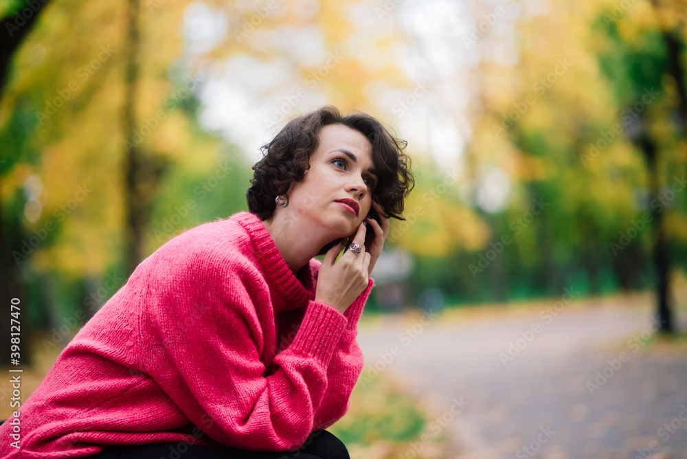 Young beautiful ballerina in fair coat and pointe shoes sit on the bench, rest outdoors. Young beautiful ballerina in fair coat and pointe shoes sit on the bench, rest outdoors.