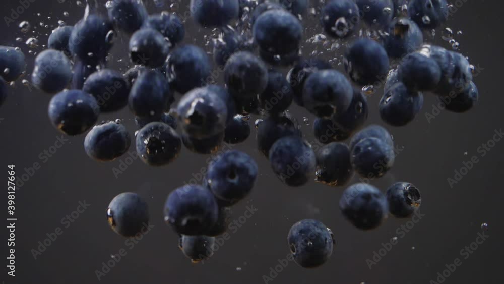 Blueberries slowly fall down into the water Blueberries slowly fall down into the water
