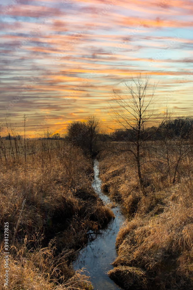 stream running through the field with sunset stream running through the field with sunset