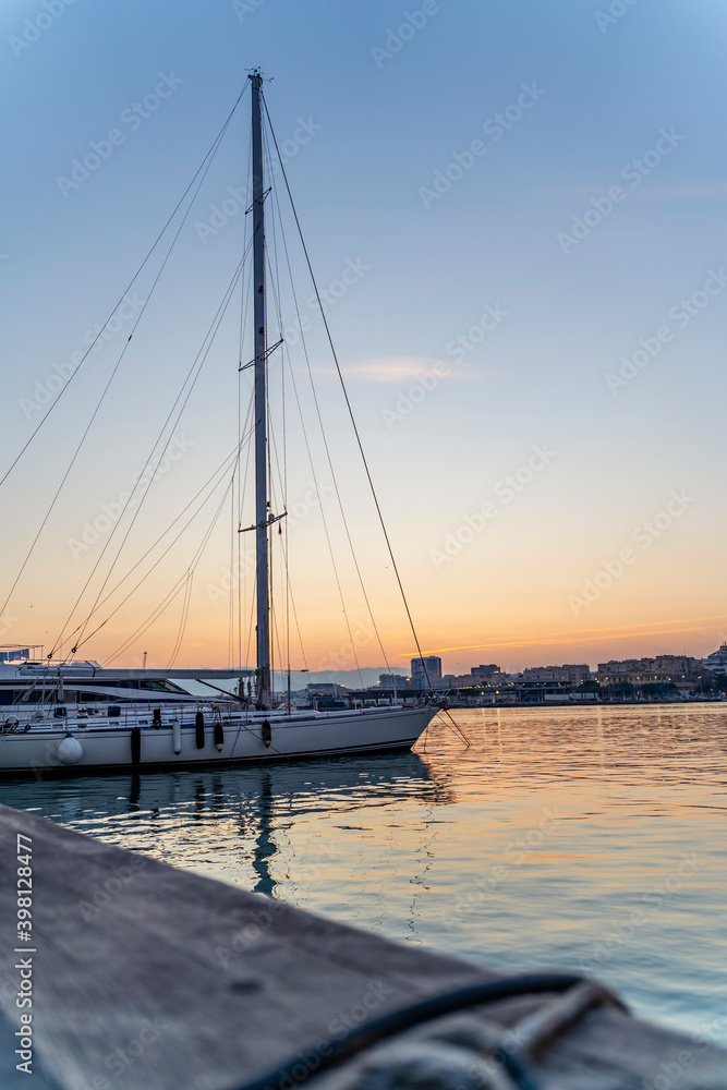 Sailing Boat with Clear Sky on Sunset with Copy Space in Port Water - Vertical Photo