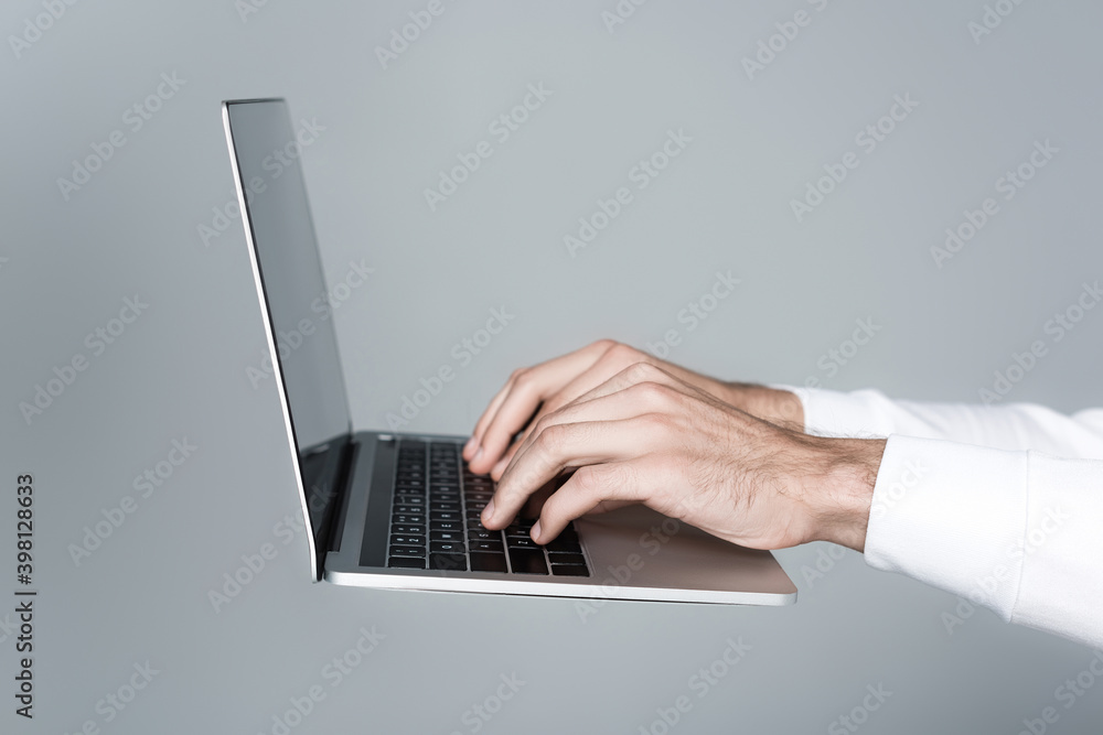 Cropped view of man using laptop isolated on grey