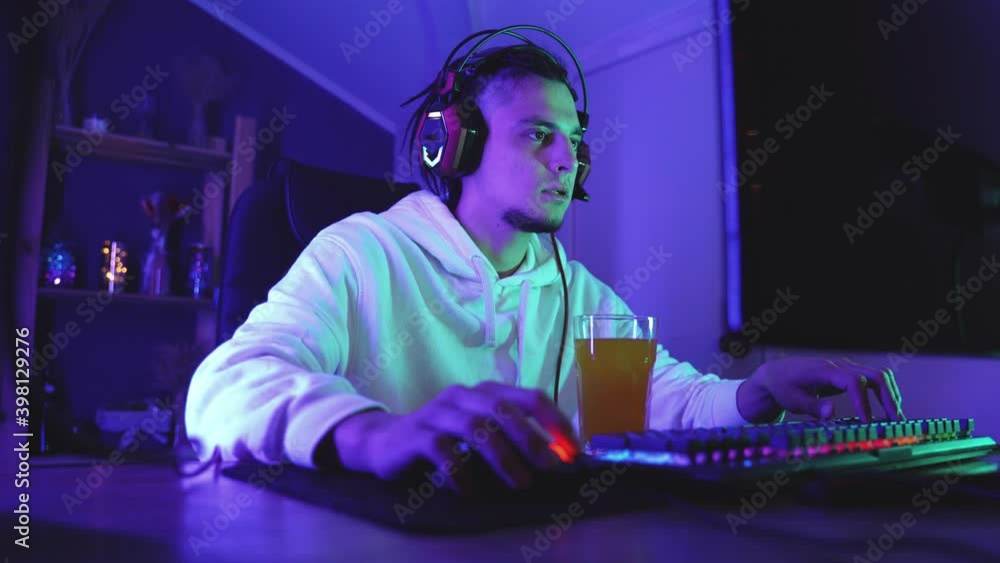 Focused gamer in headphones with microphone playing online video games Focused gamer in headphones with microphone playing online video games