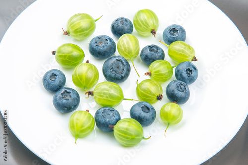 fresh different berries on a white plate. useful vitamin healthy food fruit. healthy vegetable breakfast