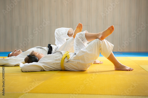Judo coach and judo girl on the floor and relaxation