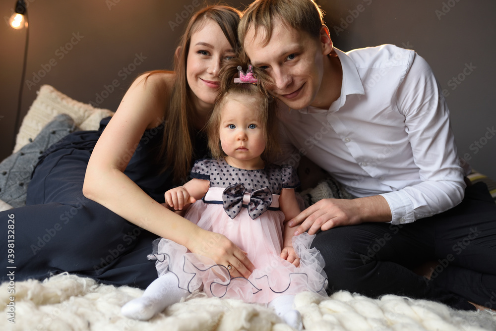 Father mom and their little one year old daughter have fun together before christmas.