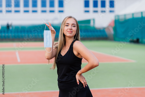 Female tennis player playing with protective mask
