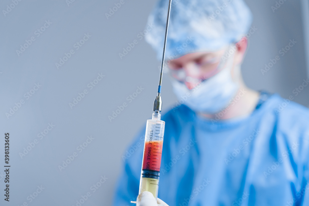 Human fat in a syringe close-up. Liposuction for lipofilling surgery operation. Plastic operation in medical clinic Human fat in a syringe close-up. Liposuction for lipofilling surgery operation. Plastic operation in medical clinic