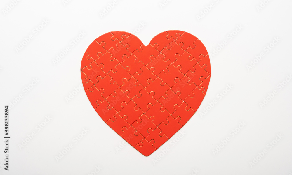 Red colored puzzle in shape of heart on white background