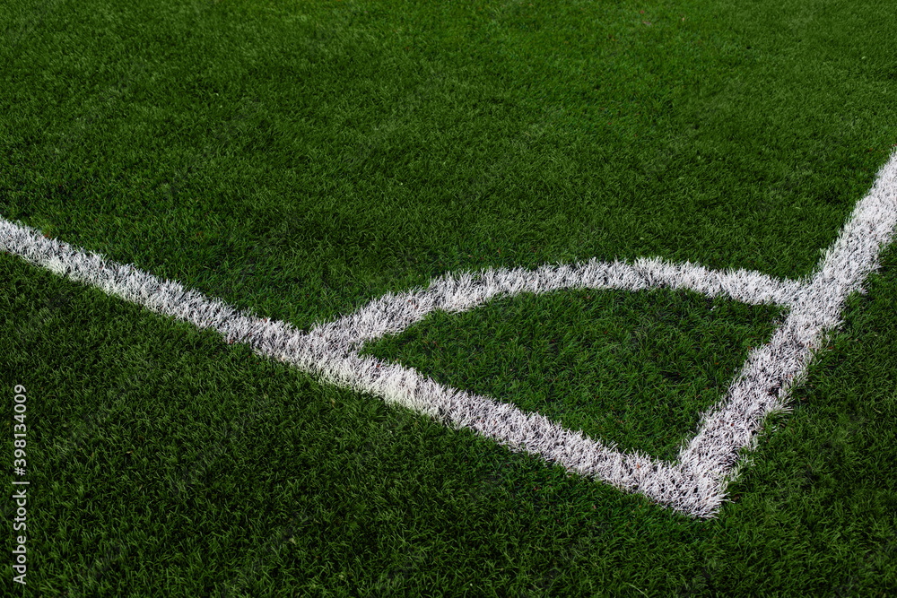 Artificial grass football field with white line corner on the green soccer field