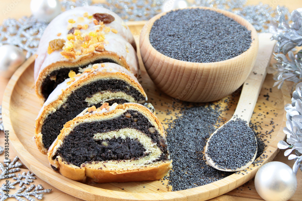 Poppy seed cake for Christmas. Next to it, poppies and Christmas decorations Poppy seed cake for Christmas. Next to it, poppies and Christmas decorations